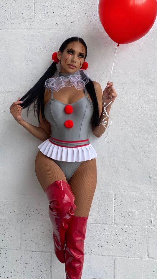 Woman in a clown costume holding a red balloon